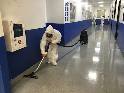 A technician in protective gear cleaning up after a water loss